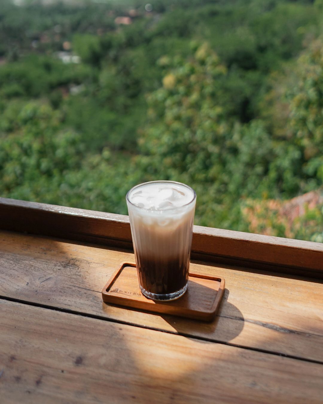 Es kopi susu dengan view pepohonan di tempat ngopi Magelang Kedai Bukit Rhema