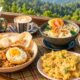 Makan setelah lari: nasi goreng, kerupuk, dan kopi di meja dengan view perbukitan Kedai Bukit Rhema
